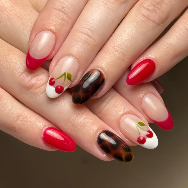 Red French tips with cherry and tortoiseshell nail art