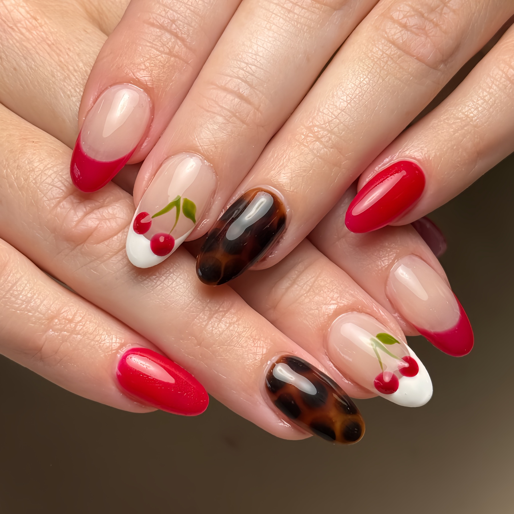 Red French tips, hand-painted cherries, and tortoiseshell nail art from Sofia's Glamour Nails Instagram